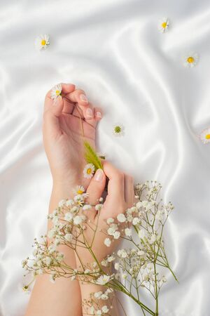 beautiful female hands on white silk with a frame.の写真素材
