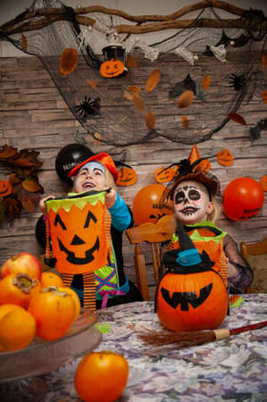 children in halloween costumes play with candyの写真素材