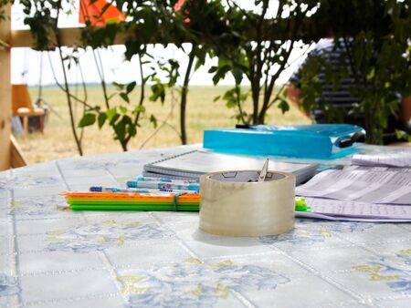 on the table under a canopy of branches lie tape and stationeryの写真素材