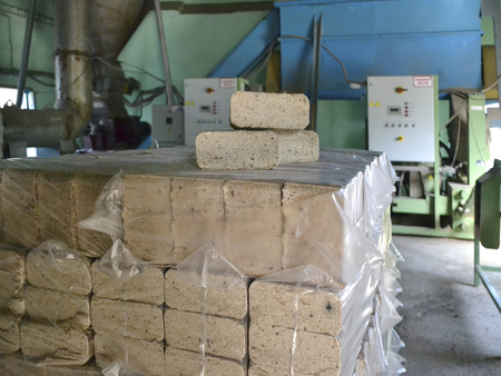 Compressed sawdust briquettes for heating in the package in the premises of the production plantの写真素材