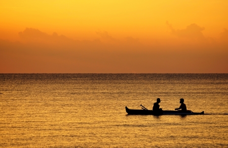 Fisherman on a boat at sunset の写真素材
