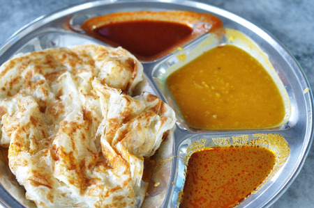 Roti canai flat bread, Indian food, made from wheat flour dough  Famous malaysian dish, Roti canai and curry の写真素材
