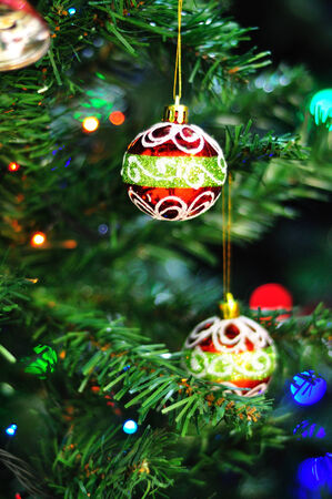 Christmas colorful balls on a christmas tree with light at backgroundの写真素材