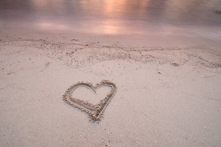 Heart or love shape handwritten on a beach