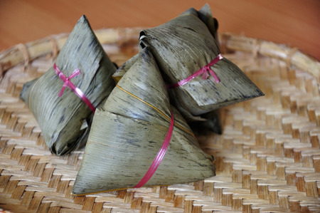 Chinese rice dumplings  or zongzi  a traditional Chinese food, made of glutinous rice stuffed with different fillings and wrapped in bamboo, reed or large flat leaves. Its served during festival.の写真素材