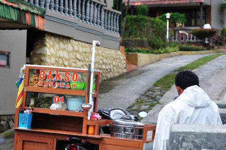 SURABAYA INDONESIA  MAY 12: Bakso seller waiting for customer near his stall on May 12 2015. Bakso is a famous Indonesia meatball or meat paste made from beef surimi served with noddle and soup.のeditorial素材
