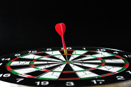 Red darts on bullseye target.