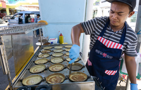 Kota Kinabalu, Malaysia - August 01, 2017: Man cooking a Malaysian sweet food known as Apam Balik or pancake at segama area in Kota Kinabalu city, Sabah Borneo.のeditorial素材