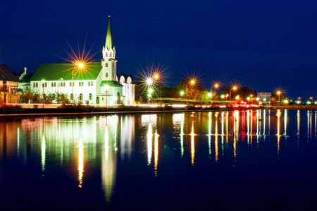 Night view of the Free Church in Reykjavík, Frikirkjan i Iceland over the Tjornin lake in Iceland.の写真素材