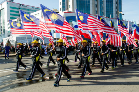 Kota KInabalu, Malaysia - August 31, 2016: Participants waving a Malaysian flags during Malaysia's  59th Independence Day parade held in Kota Kinabalu City Square.のeditorial素材