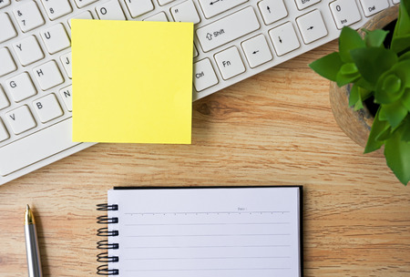 Open notepad and sticky notes on top of wooden tableの写真素材