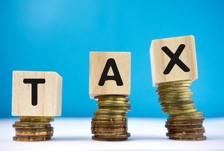 Tax word on top of coins stackの写真素材