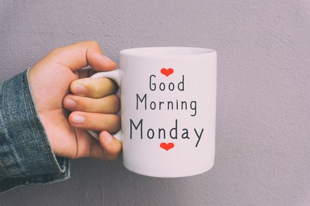 Hands holding coffee mug with text Good morning Monday. Retro Style.の写真素材