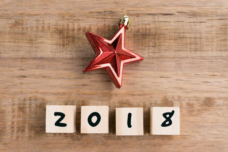Number 2018 on wooden block with Christmas ornament, retro style wooden background.の写真素材