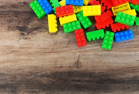 Colorful toy building blocks on wood background with copy space