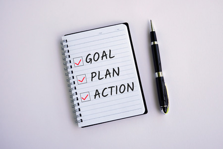Text  Goal, Plan, Action and checklist on notepad white backgroundの写真素材