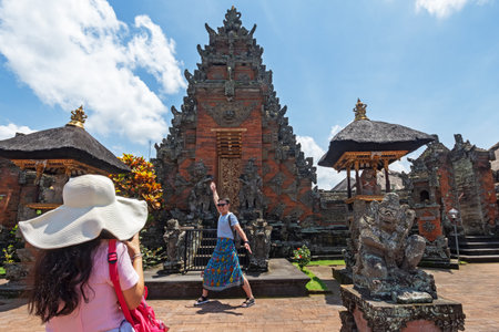 Bali, Indonesia - September 15, 2018: Tourist taking photo at Puseh temple, located at Batuan village. It is a Balinese temple with interesting stone carvings & sculptures.のeditorial素材
