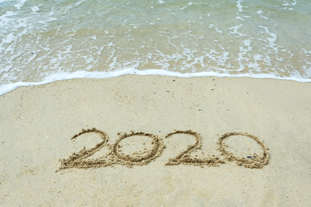 Year 2020 number on a sand beach with waves - New Year conceptの写真素材