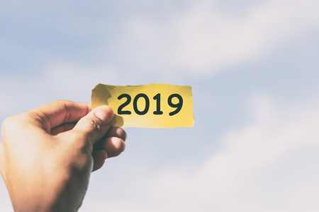 Hands holding piece of paper with number 2019の写真素材