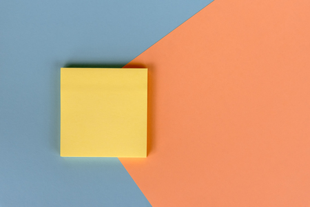 Yellow sticky note with copy space on colored backgroundの写真素材