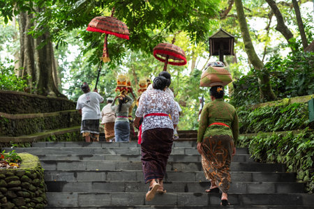 Ubud, Indonesia - April 04, 2019: Balinese parade with women carrying offering for Hindu God in Ubud Monkey Forest Templeのeditorial素材
