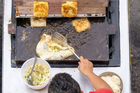 Top view of a man hand cooking vegetables martabak jawa in Kota Kinabalu City open market in Sabah Borneo. Martabak Jawa also known as stuffed pancake or pan-fried bread, murtabak and mutabbaq.の写真素材