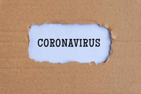 Coronavirus text on torn paper - health concept.の写真素材