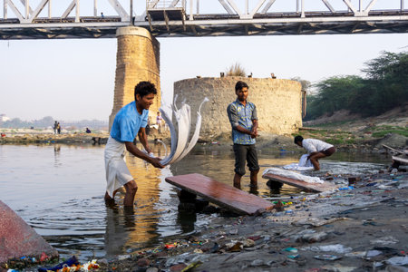 Uttar Pradesh, India - March 03, 2018: Unidentified man doing a laundry at Dhobi Ghat is a well known open air laundromat in Yamuna River, Agra.のeditorial素材
