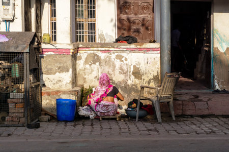 New Delhi, India - March 03, 2018: Unidentified Indian woman washing clothes outside her house.のeditorial素材
