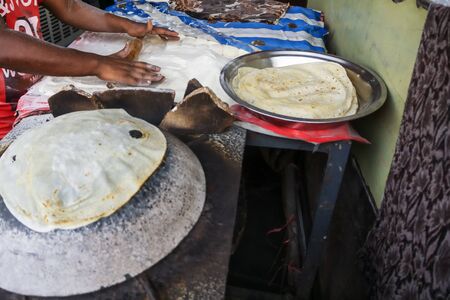 Man Preparing and cooking chapati roti at Chandni Chowk in Old Delhi Indiaの写真素材