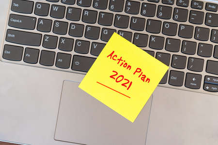 Action plan 2021 on yellow adhesive yellow paper note on top of laptopの写真素材