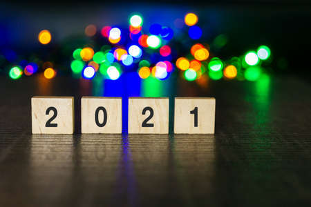 Number 2021 on wooden block with Christmas light bokehの写真素材