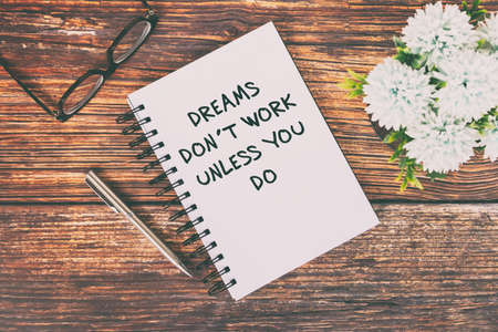 Motivational and Inspirational Quotes text on notepad - Dreams don't work unless you do.の写真素材