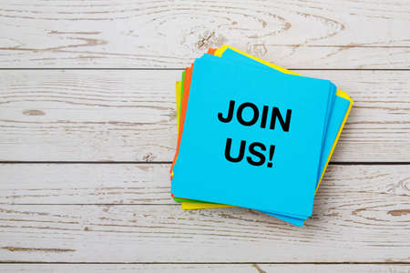 Join us text on paper note on top of wooden table