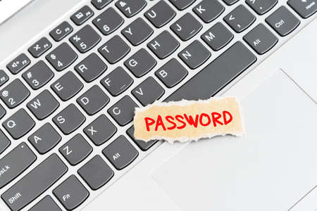 Password text on torn paper on top of laptop keyboard