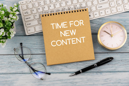 Time for new content text on notepad on top of office deskの写真素材