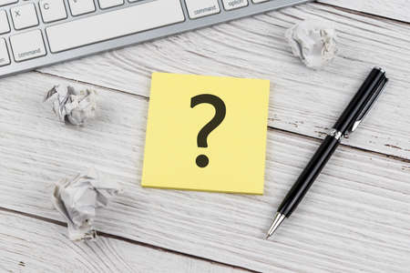Question mark on adhesive note on top of office desk