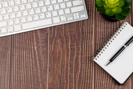 Top view of office desk with computer keyboard and note padの写真素材