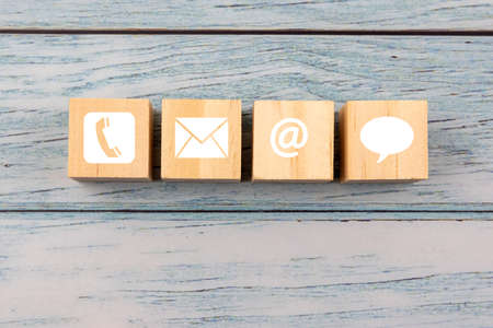 Contact us icon on wood block - business conceptの写真素材