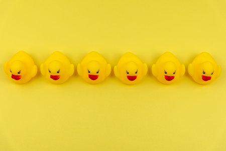 Directly above view of yellow duck in row on yellow backgroundの写真素材