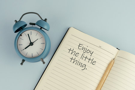 Inspirational quote - Enjoy the little thing text on note pad with alarm clockの写真素材