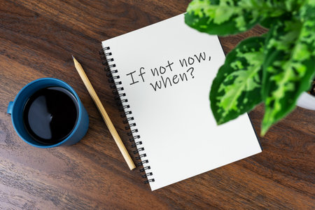 Coffee and note pad with text - If not now whenの写真素材