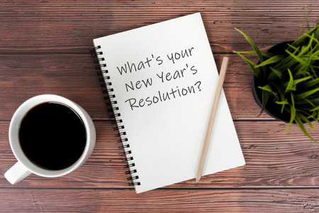 Cup of coffee and notepad with text What's your New Year's Resolutionsの写真素材