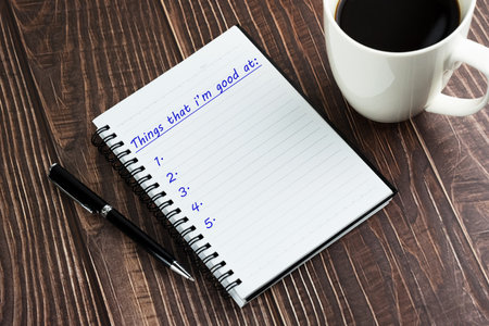 Things that I'm good at list text on notepad and cup of coffee on top of tableの写真素材