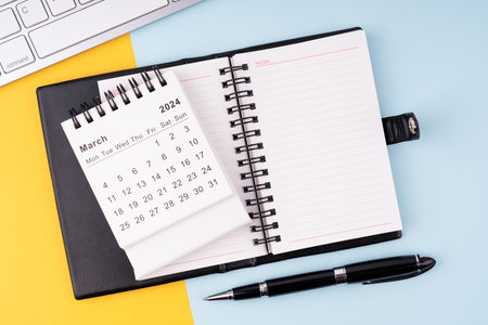 March 2024 calendar, notepad, pen and computer keyboardの写真素材