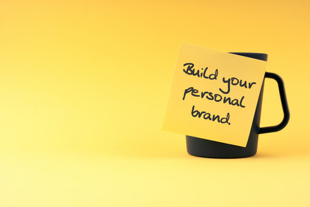 Build your personal brand text on sticky yellow adhesive note  on yellow backgroundの写真素材
