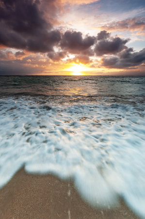 Sea foam at the beach during sunrise exposure wavesの写真素材