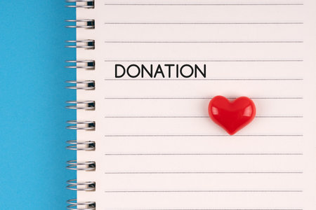 Heart shape on notepad with text donationの写真素材