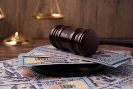 Gavel on top of American 100 dollars money and scale of justiceの写真素材