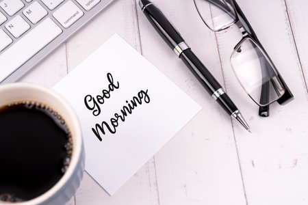 Cup of coffee and good morning note on a deskの写真素材